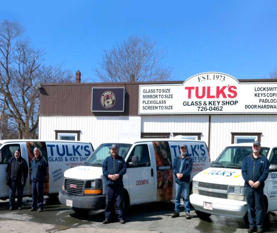 men standing in front of company trucks on the lot of Tuck's Glass and Key Shop
